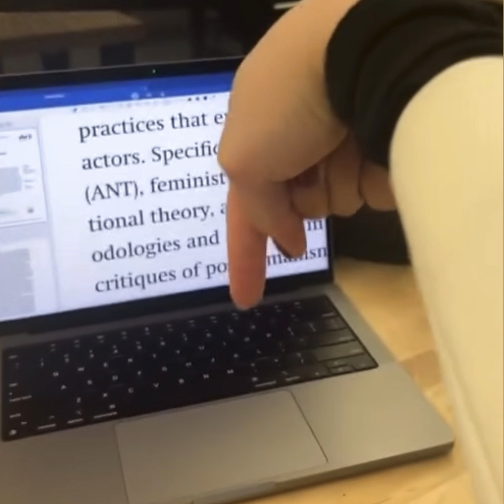 E-Book Gesture Controller: finger reaching toward a laptop screen displaying academic text, demonstrating gesture-based e-book interaction